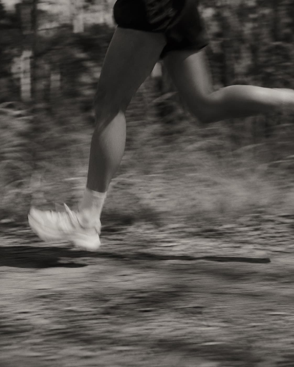 A runner mid-stride on a forest trail